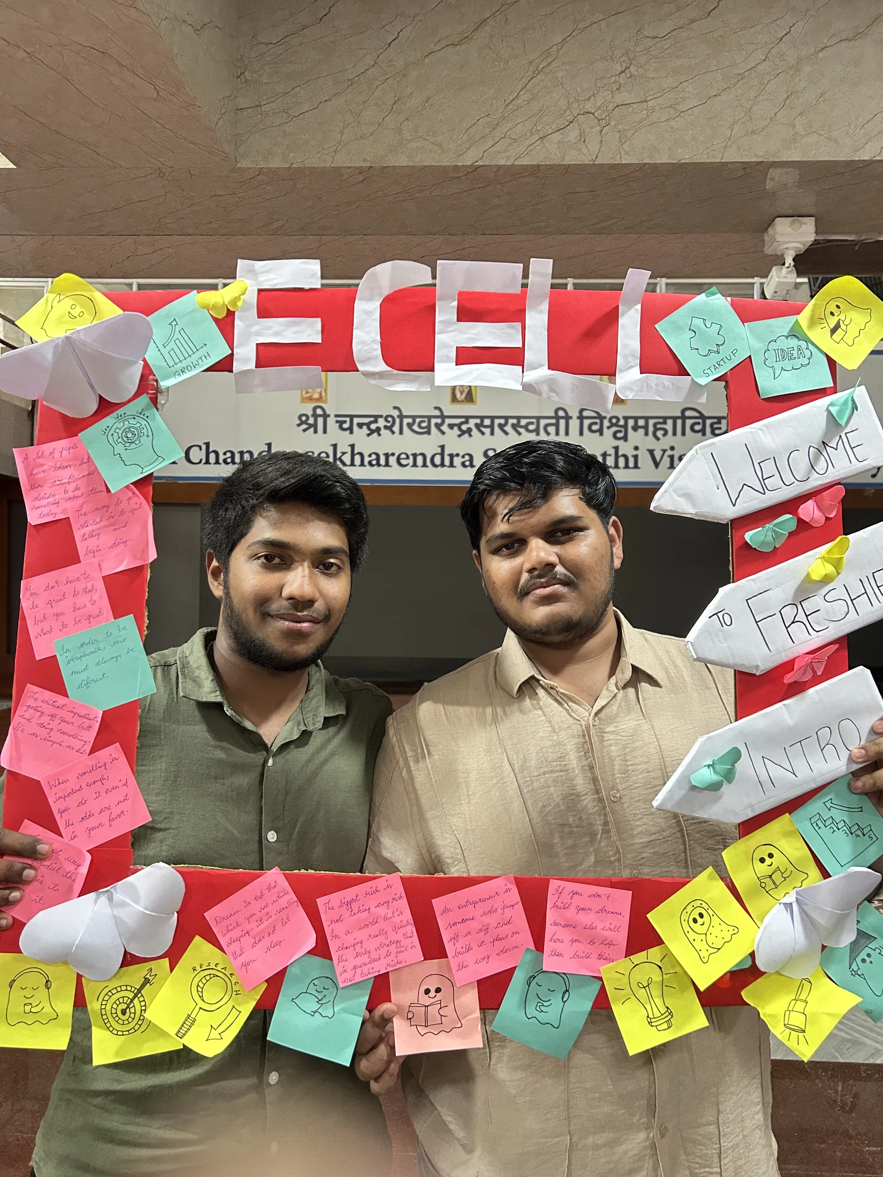 Two students posing with the E-Cell welcome frame after APEX